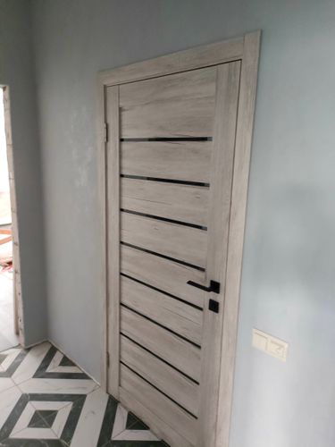 Установлена новая створка, закреплены петли, врезан замок, смонтирована коробка, отрегулирована фурнитура, проверена плавность открывания, добавлены наличники, выполнена подгонка.