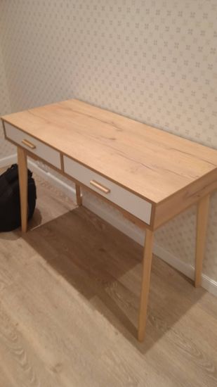 Собрана новая мебель: установлены ножки, закреплены ящики, прикреплена столешница. Все детали тщательно подогнаны, обеспечена устойчивость и функциональность конструкции.