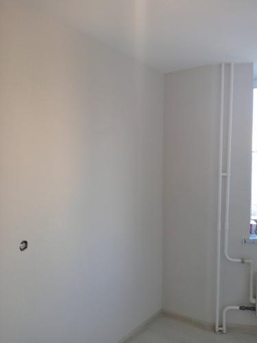 Стены оклеены светлыми обоями, поверхность ровная, без видимых стыков и дефектов. Углы аккуратно обработаны, трубы и розетки учтены, создавая завершенный и опрятный вид.