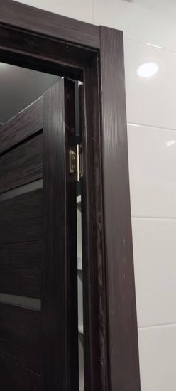 Установлены деревянные элементы вокруг дверного проема, обеспечивая аккуратный и завершенный вид. Все детали подогнаны и закреплены, создавая гармоничный интерьер.