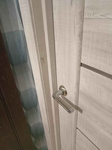 Установлены декоративные элементы вокруг дверного проема, обеспечивая аккуратное и эстетичное завершение. Все детали плотно прилегают, создавая гармоничный вид.