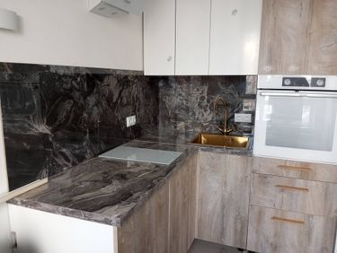 Установлена новая столешница из ДСП, идеально подогнанная по размеру. Выполнен монтаж мойки и варочной панели, обеспечена надежная фиксация и герметизация всех стыков.