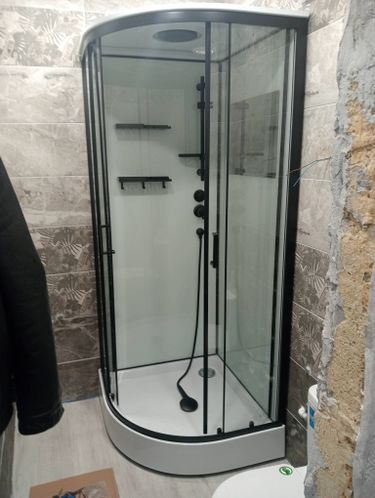 Установлена современная душевая кабина с прозрачными дверями и черной фурнитурой. Обновлены стены, уложена плитка, заменен слив. Пространство стало более функциональным и стильным.