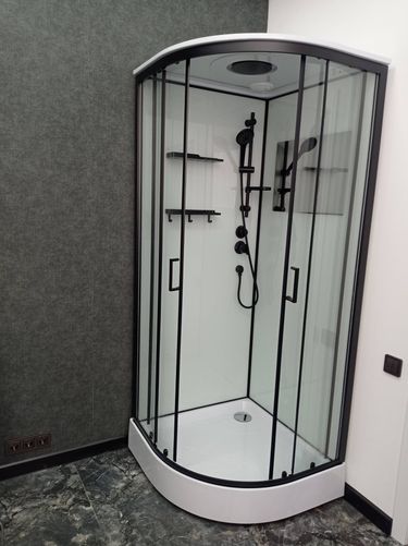 Установлена современная душевая конструкция с низким основанием, герметично закреплены стеклянные панели, подключены смеситель и лейка, проверена работа слива и водоснабжения.