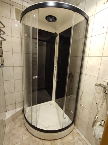 Установлена душевая конструкция с низким основанием. Подключены водопроводные и сливные коммуникации. Закреплены стеклянные панели, проверена герметичность. Завершена настройка дверей.