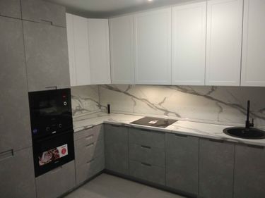 На изображении завершён монтаж кухонных панелей. Выполнена точная подгонка и установка фасадов, обеспечивающая современный и аккуратный вид интерьера.