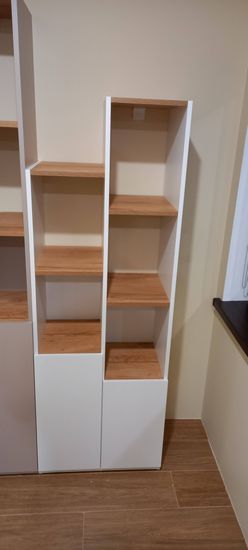 Собран и установлен функциональный стеллаж с несколькими полками. Конструкция надежно закреплена, обеспечивая устойчивость и практичность для хранения вещей в интерьере.