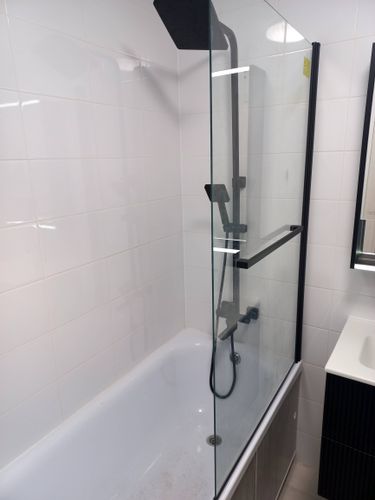 Установлено большое стекло в ванной комнате, закреплено на стене, обеспечивая защиту от брызг. Работа завершена аккуратно, без видимых дефектов, гармонично вписывается в интерьер.