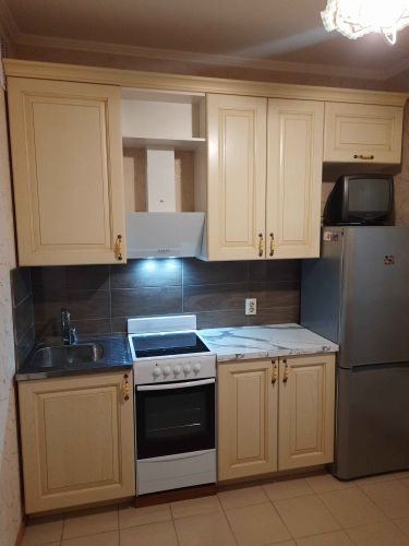 Установлены шкафы, смонтирована столешница, подключены мойка и плита, закреплена вытяжка, размещены ручки. Завершена отделка стен плиткой. Установлена бытовая техника.