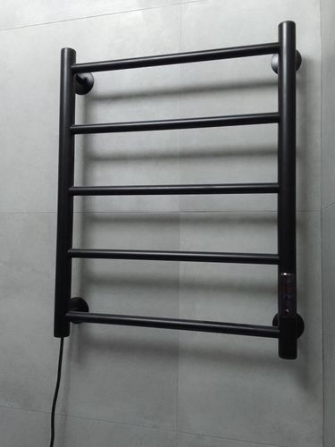 Установлен новый черный полотенцесушитель на стену в ванной комнате, подключен к электросети, проверена исправность.