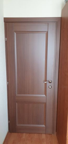 Установлена новая деревянная дверь с ручкой и замком. Проведена регулировка петель, обеспечивающая плавное закрытие. Осуществлён монтаж наличников, скрывающих зазоры.