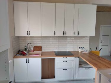 Установлены шкафы, закреплены фасады, смонтирована столешница, подключена мойка, встроена варочная панель, установлены ручки, выполнена облицовка фартука плиткой.