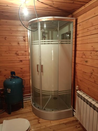 Установлена современная душевая конструкция с герметичными дверцами и подключением к водопроводу. Проведены работы по монтажу поддона и фиксации стенок в деревянном интерьере.
