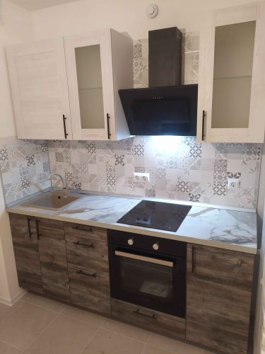 Установлены шкафы, закреплены фасады, смонтирована столешница, подключена варочная панель, врезана мойка, установлены ручки, проведены коммуникации, закреплена вытяжка, облицован фартук.