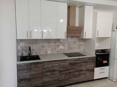 Установлены шкафы, закреплены фасады, смонтирована столешница, подключена мойка, встроена плита, установлена вытяжка, оформлен фартук, подключены все коммуникации, завершена сборка.