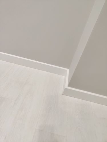 Установлен современный плинтус, гармонично сочетающийся с поверхностями. Аккуратное прилегание к стенам и полу создаёт эстетичный вид, подчеркивая минималистичный стиль интерьера.