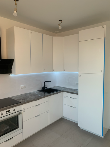 Изготовлены и установлены белоснежные панели для кухонного гарнитура, идеально подогнаны по размерам, обеспечивая современный и аккуратный вид помещения.