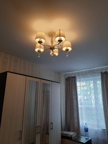 В комнате установлено новое потолочное освещение с пятью абажурами. Светильник закреплён на месте, подключён к электросети, проверена работа ламп. Интерьер освежён, освещение равномерное.