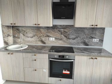 Проведена работа по точной подгонке столешницы, выполнены вырезы для раковины и варочной панели, установлены элементы, обеспечивающие функциональность и эстетичность кухонного пространства.