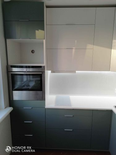 Выполнен монтаж гладкой поверхности из искусственного камня, идеально подогнанной к кухонным шкафам, с вырезами под варочную панель и мойку, обеспечивая функциональность и стильный вид.