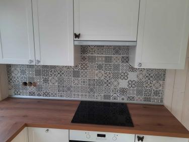 Установлены шкафы, закреплены фасады, смонтирована столешница, подключена варочная панель, оформлен фартук из плитки, установлены ручки, проведены коммуникации.