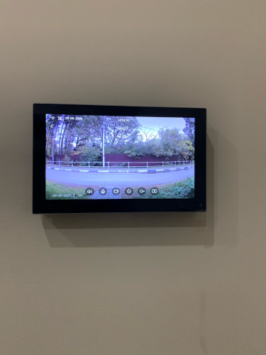 На стене закреплен экран видеодомофона, подключены все необходимые кабели, проверена работоспособность системы, настроено изображение для четкой передачи видео с камеры.