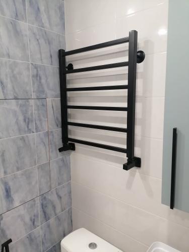 Установлен новый черный полотенцедержатель на стену в ванной комнате, обеспечивая современный вид и функциональность. Завершены все монтажные работы, подключение выполнено аккуратно.