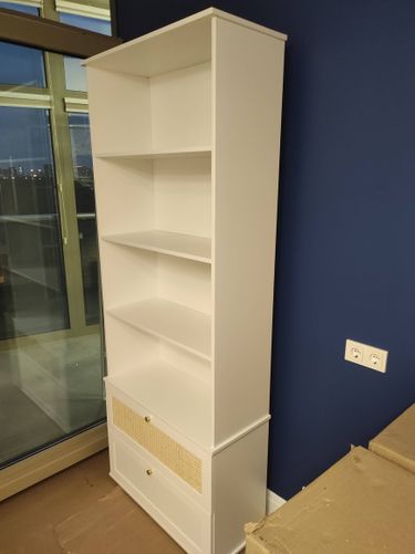 Собран белый стеллаж с полками и ящиками, установлен у стены. Работа завершена, конструкция устойчива, элементы надежно закреплены, внешний вид аккуратный, соответствует интерьеру.