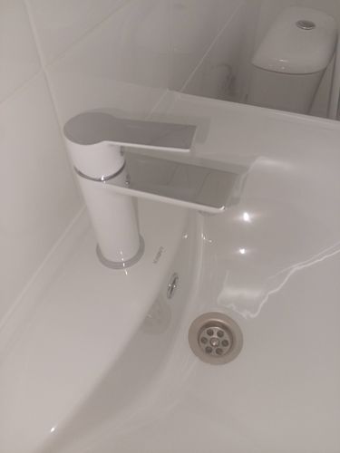 Изображен установленный новый смеситель на раковине, подключены все коммуникации, проверена герметичность соединений, обеспечена функциональность и эстетичный вид.