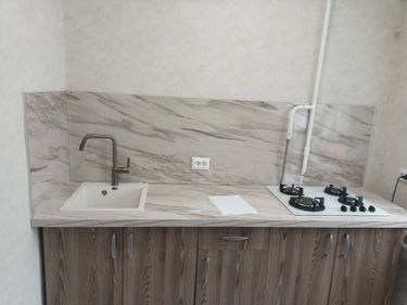 Потолок аккуратно обшит панелями, создающими ровную поверхность. Все стыки тщательно замаскированы, обеспечивая эстетичный вид. Установлены светильники, завершив обновление интерьера.