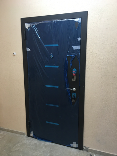 Установлена металлическая дверь с защитной пленкой, закреплены петли, врезан замок, выровнена рама, проверена герметичность, обеспечена надежная фиксация, завершены отделочные работы.