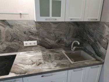 Выполнена точная подгонка каменной поверхности, установлена мойка, вырезаны отверстия для варочной панели и смесителя. Обеспечена идеальная стыковка и гладкость краев.