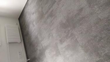 На ровное основание уложено новое покрытие, тщательно подогнанное по краям. Все стыки аккуратно соединены, создавая гладкую и ровную поверхность.