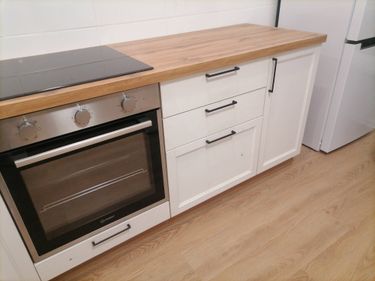 Установлены шкафы, закреплена столешница из дерева, вмонтирована варочная панель, установлена техника, прикреплены ручки, отрегулированы дверцы, завершена сборка кухонного гарнитура.