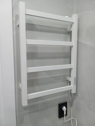 Установлен электрический полотенцесушитель: закреплен на стене, подключен к розетке, проверена работоспособность, обеспечена безопасность использования, выполнена чистовая отделка.