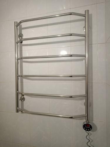 Установлено новое оборудование в ванной комнате. Металлическая конструкция закреплена на стене, подключена к электросети, проверена работоспособность, обеспечена надежная фиксация.