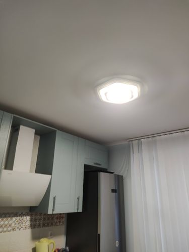 На потолке закреплён светильник с люминесцентными лампами. Проведены работы по подключению к электросети, обеспечена надёжная фиксация и проверена работоспособность устройства.