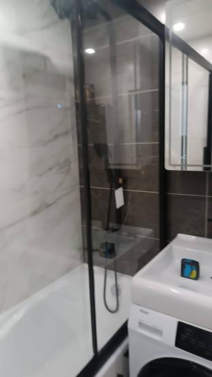 Установлена акриловая ванна, подключены водопроводные коммуникации, закреплены стеклянные перегородки, проверена герметичность, завершена отделка стен плиткой, установлены смесители.