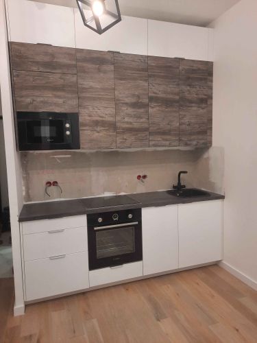 Установлены шкафы, смонтирована столешница, врезана варочная панель и раковина, подключены бытовые приборы, закреплены фасады, установлены ручки, проведены коммуникации.