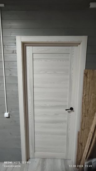 Установлена деревянная створка, закреплена коробка, врезаны петли, прикреплена ручка, отрегулированы зазоры, проверена плавность хода, выполнена отделка наличниками, завершён монтаж.