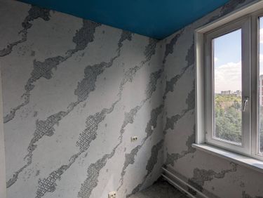 На стенах аккуратно наклеены фотообои с абстрактным узором, создающим стильный и современный вид. Поверхность ровная, без видимых стыков и пузырей, что обеспечивает эстетичный результат.