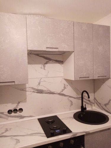 Отрезка поверхности выполнена точно, установлены варочная панель и раковина, подогнаны края, обеспечена гладкость и аккуратность соединений, завершена установка кухонного гарнитура.