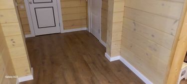 Выполнена установка плинтуса, который аккуратно интегрирован в стены, создавая плавный переход между полом и стеной. Завершённый вид подчёркивает стиль и аккуратность интерьера.