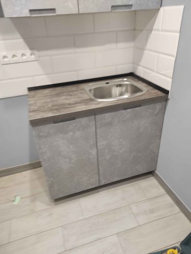 Установлены кухонные шкафы, закреплена столешница, вмонтирована мойка, подключены коммуникации, облицована стена плиткой, отрегулированы дверцы, завершена сборка и проверка функциональности.