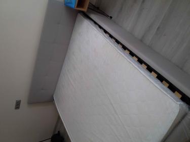 Собрана двуспальная кровать: установлено изголовье, закреплены боковые панели, уложено основание, размещён матрас. Все элементы соединены, конструкция устойчива и готова к использованию.