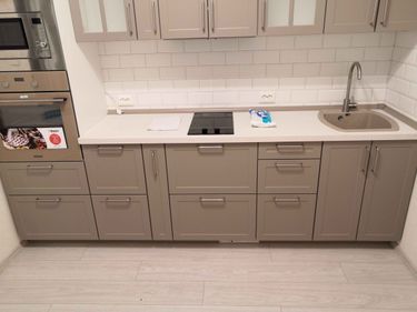 Установлены шкафы, вмонтирована столешница, подключена варочная панель и мойка, смонтированы фасады и ручки, выполнена подводка коммуникаций, завершена облицовка фартука плиткой.