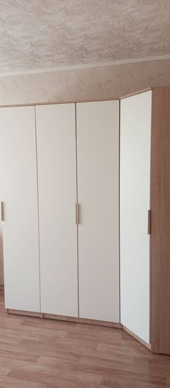 Собран шкаф: установлены двери, прикреплены ручки, закреплены боковые панели, выровнены стыки, проверена устойчивость, обеспечена функциональность, завершена сборка, проверена надежность.