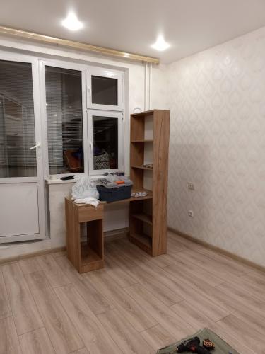 На полу уложен ламинат, создающий ровное и аккуратное покрытие. Плинтусы установлены по периметру, завершая оформление интерьера.