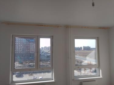 Установлены карнизы для штор над двумя окнами в светлой комнате. Завершены работы по монтажу, обеспечивающие функциональность и эстетичный вид интерьера.