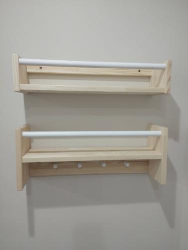 На стене закреплены две деревянные полки с металлическими перекладинами. Установлены ровно, надежно, без видимых дефектов. Полки готовы к использованию для хранения предметов.